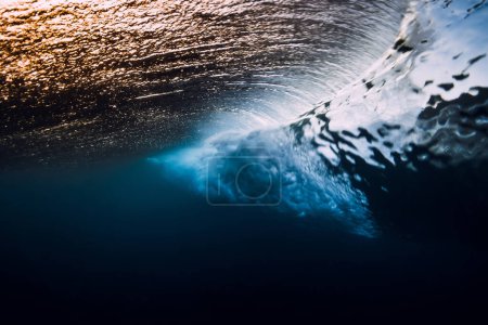 Photo for Barrel wave breaking in ocean with sunset or sunrise light. Underwater view of surfing wave - Royalty Free Image