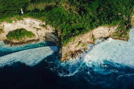 Foto de Aerial view of coastline with rocky cliffs, ocean with waves and lighthouse in Bali - Imagen libre de derechos