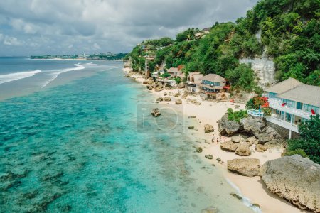 Foto de Aerial view of quiet blue ocean and beach coastline with cozy hotels on Impossibles beach in Bali - Imagen libre de derechos