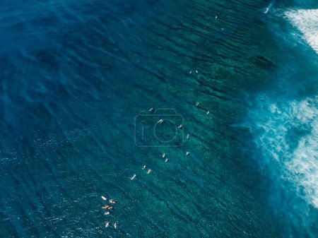 Foto de Vista aérea del océano azul transparente con surfistas. Lugar de surf en la isla tropical - Imagen libre de derechos