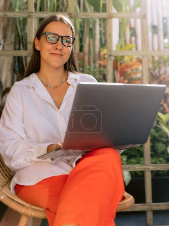 Téléchargez les photos : Freelance travaillant sur ordinateur portable tout en étant assis près de la fenêtre dans un bureau créatif ou un café d'été - en image libre de droit