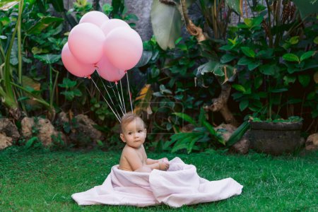 Photo for Baby girl and air balloons swim in baby bath outdoor garden. Happy baby. - Royalty Free Image