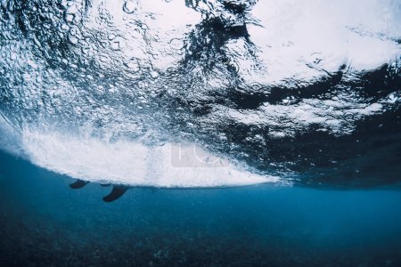 Téléchargez les photos : Vague sous-marine et surf sur planche de surf dans l'océan. Vague d'écrasement sous-marin et planche de surf en eau transparente - en image libre de droit