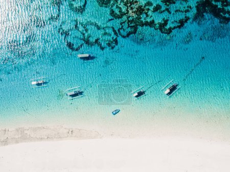 Foto de Barcos de pesca en el océano azul y playa de arena blanca en la isla paradisíaca. Vista aérea. - Imagen libre de derechos