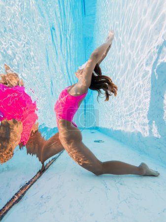 Photo for Attractive young woman in pink sexy swimwear underwater in swimming pool, posing and tanned on summer vacation. Healthy body care - Royalty Free Image