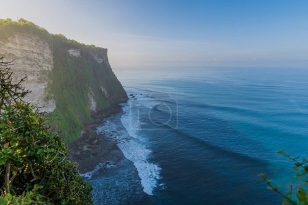 Foto de Escénico acantilado rocoso con luz de la mañana y el océano con olas en Uluwatu, Bali - Imagen libre de derechos