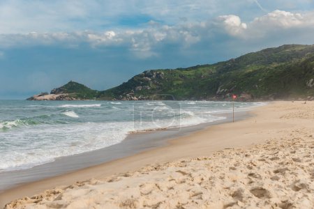 Photo for Scenic sandy beach with sunset light before an oncoming storm. Mole beach in Florianopolis - Royalty Free Image