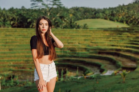 Téléchargez les photos : Belle femme sexy sur les terrasses de hausse avec la lumière du soleil du matin à Bali - en image libre de droit