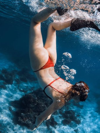 Téléchargez les photos : Femme sexy en bikini plongée sous-marine dans l'océan bleu. - en image libre de droit