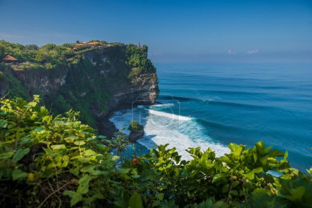 Foto de Escénico acantilado rocoso y océano con olas en Uluwatu, Bali. Lugar popular con templo balinés - Imagen libre de derechos