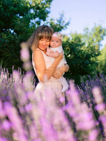 Foto de Disfrutando de la madre con su hija al aire libre con flores de lavanda - Imagen libre de derechos