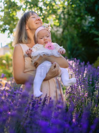 Foto de Disfrutando de la madre con su hija al aire libre con flores de lavanda - Imagen libre de derechos