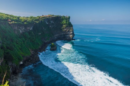 Foto de Escénico acantilado rocoso y océano con olas en Uluwatu, Bali. Lugar turístico popular con templo balinés - Imagen libre de derechos