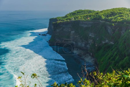 Foto de Escénico acantilado rocoso y océano con olas en Uluwatu, Bali. Lugar turístico popular con templo balinés - Imagen libre de derechos