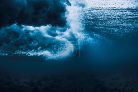 Foto de Ola bajo el agua y tabla de surf en el océano azul. Vista submarina de la ola que se estrella en agua transparente - Imagen libre de derechos