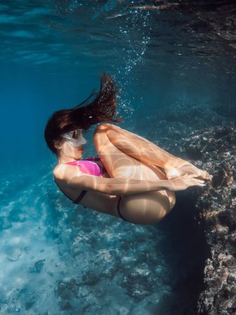 Téléchargez les photos : Jeune femme en bikini posant sous l'eau en mer tropicale transparente. - en image libre de droit