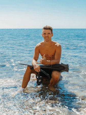Photo for Sexy topless male model vacation on the ocean beach. Smiling sporty male after diving - Royalty Free Image