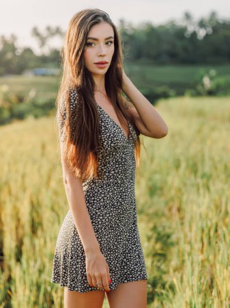 Photo for Gorgeous young woman with beautiful hairs on rise terraces in Bali with morning sunlight. Glamour lady at rice field - Royalty Free Image