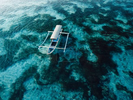 Foto de Barco anclado en el océano azul transparente en la isla tropical. Vista aérea. - Imagen libre de derechos