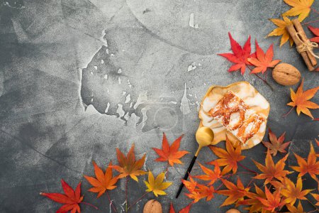 Téléchargez les photos : Composition avec feuilles d'érable d'automne, noix, gâteau aux pommes et assiette d'art en résine sur fond de pierre. Concept automnal de jour d'action de grâces. Couché plat, vue du dessus - en image libre de droit