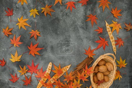 Téléchargez les photos : Cadre fait de feuilles d'érable d'automne, noix sur fond sombre. Concept automnal. Couché plat, vue du dessus - en image libre de droit