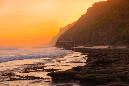 Téléchargez les photos : Côtes avec océan, vagues et soleil chaud au coucher du soleil à Bali - en image libre de droit