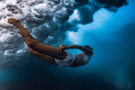 Téléchargez les photos : Femme plongée sous les vagues de l'océan. Plongée du canard sous la vague du tonneau dans un océan transparent - en image libre de droit