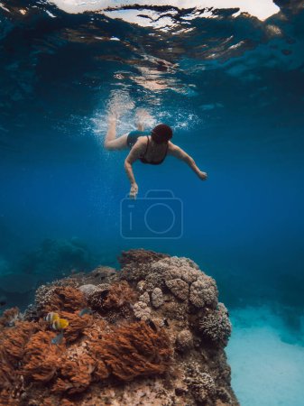 Foto de Mujer de 60 años haciendo snorkel cerca de corales en el mar azul tropical. Esnórquel en vacaciones en Hawaii - Imagen libre de derechos