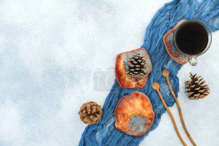 Foto de Composición con taza de café y placas de arte de resina sobre fondo de piedra azul. Piso tendido, vista superior - Imagen libre de derechos