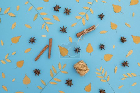 Photo for Thanksgiving day or Autumnal composition made of fall leaves and cinnamon on blue background. Flat lay, top view. - Royalty Free Image