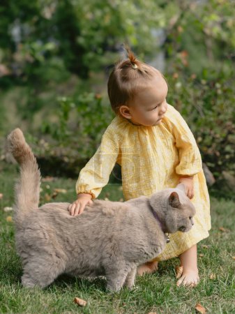 Photo for Beautiful child girl and fluffy cat in backyard garden - Royalty Free Image