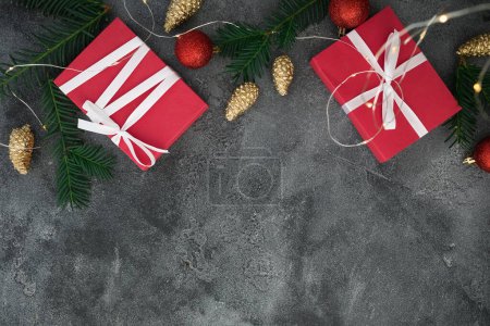 Photo for Christmas composition with branches, gifts and golden decoration on dark background. Flat lay - Royalty Free Image