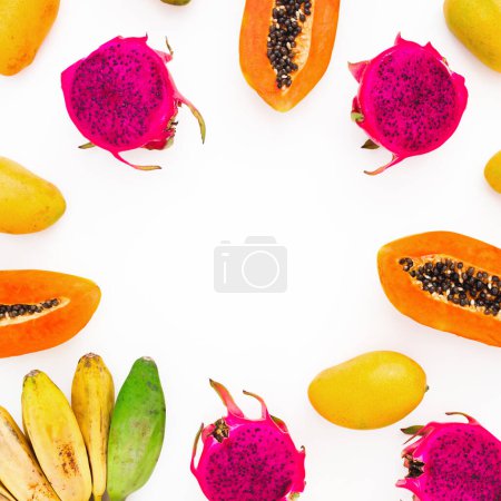 Téléchargez les photos : Fruits fond de banane, papaye et mangue jaune avec des fruits du dragon sur blanc. Pose plate. Vue de dessus. Concept d'aliments tropicaux - en image libre de droit