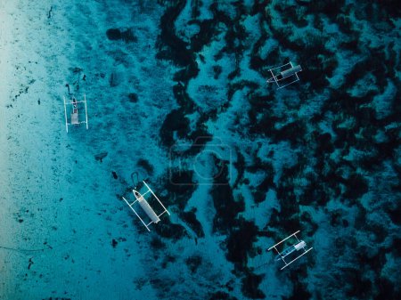 Photo for Fishing boats at anchor in blue transparent ocean on tropical island. Aerial view. - Royalty Free Image