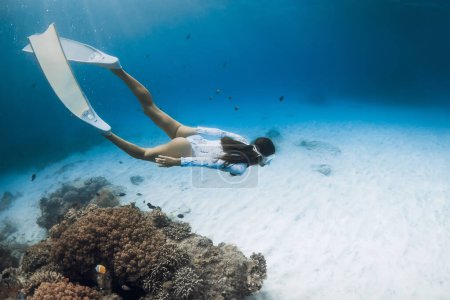 Photo for Woman freediver with fins dive underwater. Freediving with beautiful lady in clear blue ocean - Royalty Free Image