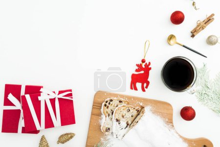 Photo for Christmas table with tasty stollen cake, coffee cup, tree toys and gift boxes on white. Flat lay, top view. - Royalty Free Image