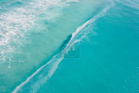 Téléchargez les photos : Océan bleu clair et vague de surf. Rêve de surf sous les tropiques. Vue aérienne - en image libre de droit