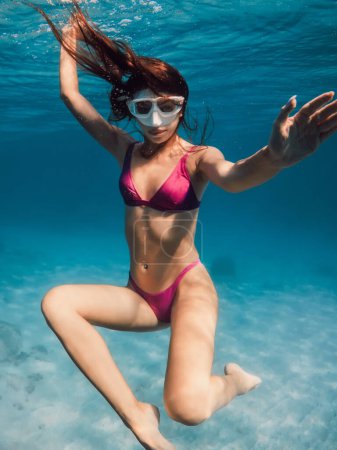 Photo for Young woman in bikini swimming and fun underwater in blue ocean. - Royalty Free Image