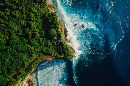 Foto de Vista aérea de la costa con acantilados rocosos, océano con olas y faro en Bali - Imagen libre de derechos