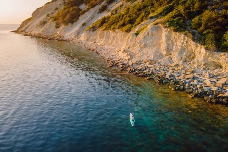 Téléchargez les photos : Voyager sur stand up paddle board à la mer calme avec paysage méditerranéen pittoresque. Vue aérienne - en image libre de droit