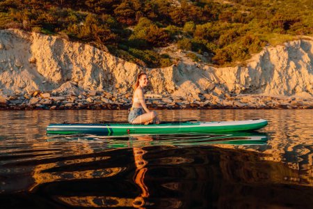 Téléchargez les photos : Femme souriante sur stand up paddle board à la mer calme. Vacances d'activité sur SUP board en mer. - en image libre de droit