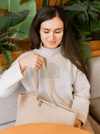 Foto de Mujer atractiva con una bolsa de paja en un café - Imagen libre de derechos