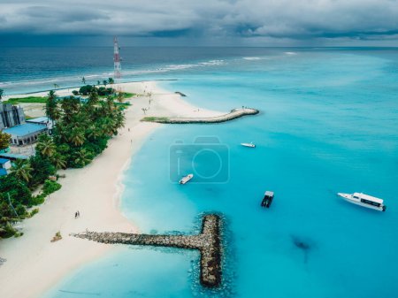 Foto de Maldivas playa tropical con muelle y lanchas rápidas en el océano azul. Concepto de vacaciones de viaje. Vista aérea - Imagen libre de derechos