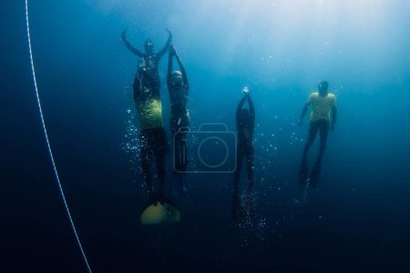Téléchargez les photos : 04 mars 2024. Nusa Penida, Indonésie. Groupe de plongeurs en combinaison de plongée amusant sous l'eau au fond de l'océan bleu. Plongée libre professionnelle en mer transparente - en image libre de droit