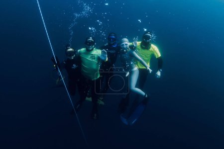 Téléchargez les photos : 04 mars 2024. Nusa Penida, Indonésie. Groupe de plongeurs en combinaison de plongée amusant sous l'eau au fond de l'océan bleu. Plongée libre professionnelle en mer transparente - en image libre de droit