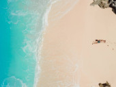 Handsome man sunbathing at tropical ocean beach. Aerial view Stickers #708734534