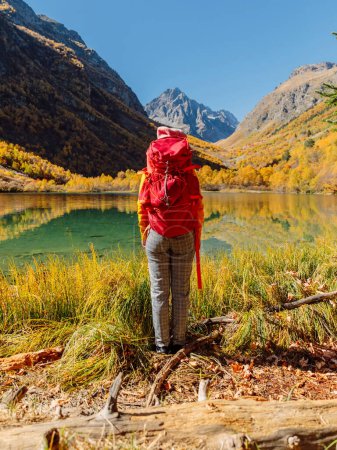 Foto de Mujer viajera en el lago de la montaña. Lago y excursionista con mochila - Imagen libre de derechos