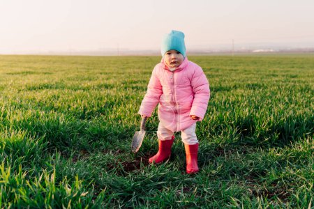 Foto de Retrato de niña en el campo con una pala - Imagen libre de derechos