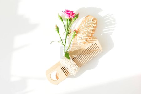 Foto de Composición del marco de peluquería de rosas rosadas con cepillo de pelo sobre fondo blanco. Piso tendido, vista superior - Imagen libre de derechos