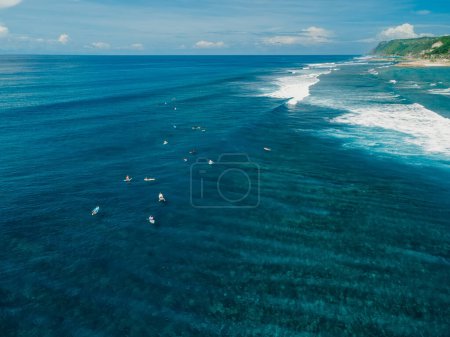 Photo for Aerial view with surfers on surf spot. Perfect waves with surfers in clear ocean - Royalty Free Image